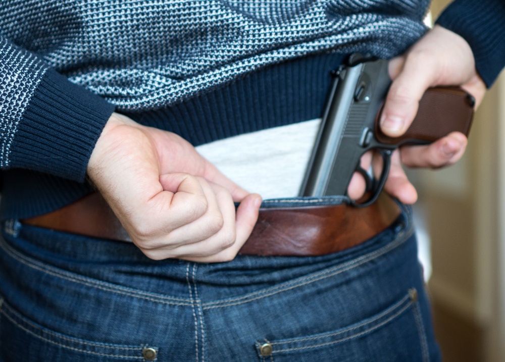 Man hiding gun behind his back.