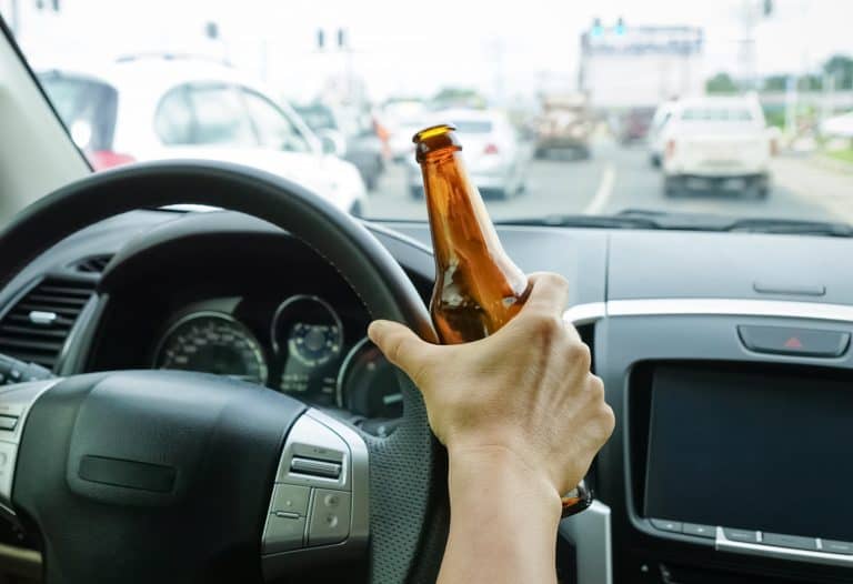 A driver holding alcoholic bottle while driving
